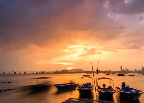motorboats-parked-water-by-water-with-sunset-city-visible